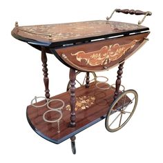 an old fashioned wooden cart with wheels on it's sides and ornate designs painted on the side