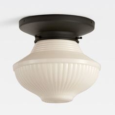 a white light fixture hanging from the ceiling with a black dome on it's top