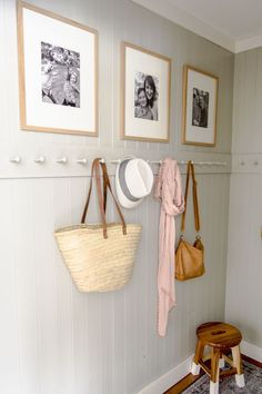 two pictures hang on the wall with hats and purses hanging from hooks in front of them