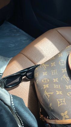 the interior of a car with sunglasses and a purse on it's back seat