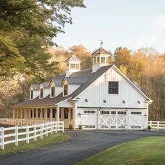 a large white barn with a black roof