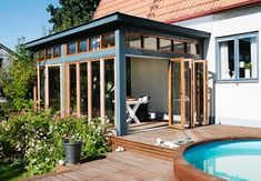 a small house with a hot tub in the yard and an enclosed patio area next to it