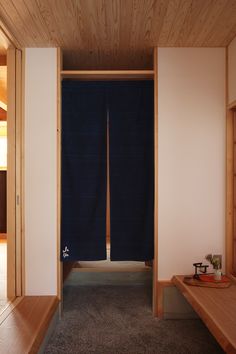 an empty room with two wooden benches and a blue curtain hanging from the wall behind it