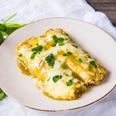 an enchilada on a white plate with parsley