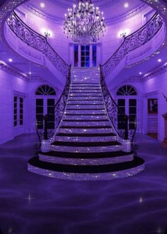 the stairs are lit up with purple lights and chandelier in the middle of the room