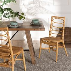 two chairs sitting at a table with plates and cups on it in front of a potted plant