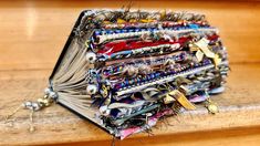 an accordion covered in lots of different types of jewelry sitting on top of a wooden table