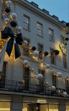 the chanel store is decorated with christmas lights and balloons in front of it's windows