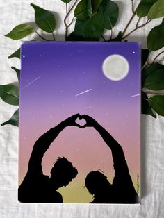 two people making a heart shape with their hands in front of the moon and stars