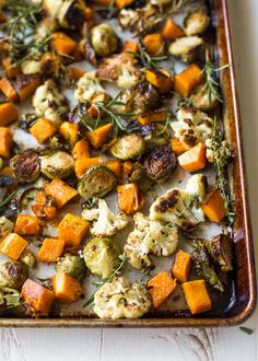 roasted vegetables and herbs on a baking sheet