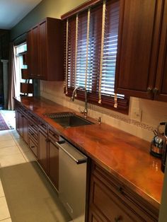 a kitchen with wooden cabinets and marble counter tops