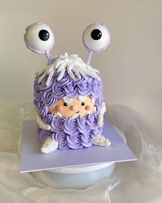 a cake with purple icing and eyes on it