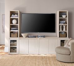 a large flat screen tv mounted to the side of a wooden entertainment center in a living room