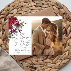 a wedding save the date card on top of a woven basket with red flowers and greenery