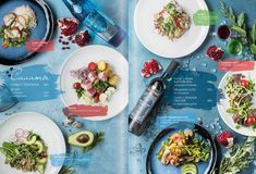 an overhead view of several plates of food on a blue table cloth with water bottles and utensils