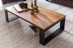 a wooden table sitting on top of a carpeted floor next to two couches