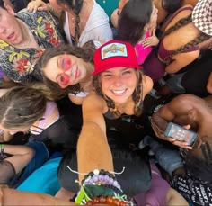 a group of people standing around each other with cell phones in their hands and one woman pointing at the camera