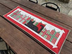 a quilted table runner sitting on top of a wooden bench next to a picnic table