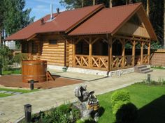 a log cabin with a hot tub in the front yard