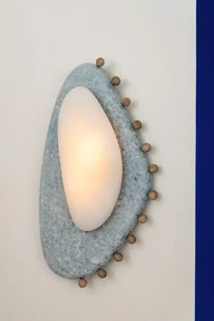 a light that is on the wall next to a blue and white wall mounted lamp