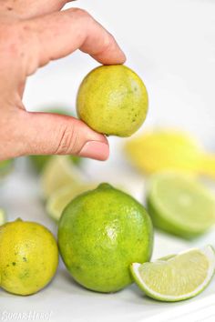 a person is squeezing limes into small lemons