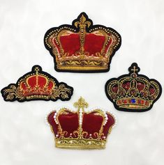 three embroidered crowns with pearls on them, one red and the other gold in color