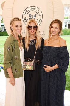 three beautiful women standing next to each other