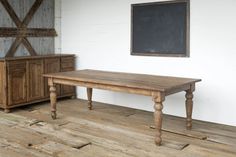 a wooden table sitting on top of a hard wood floor next to a chalkboard