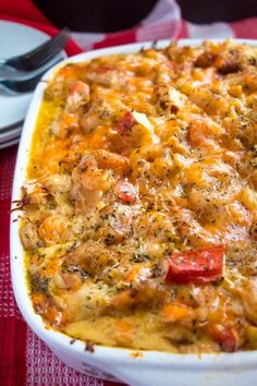 a casserole dish with meat and vegetables in it on a red table cloth