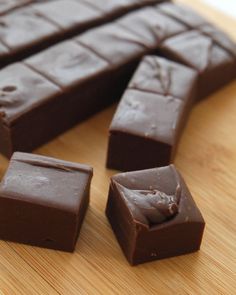 pieces of chocolate sitting on top of a wooden cutting board