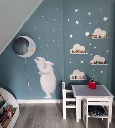 a child's room with blue walls and white stars on the wall, including a teddy bear holding a balloon