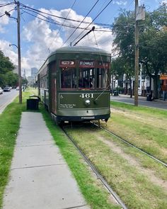 an old trolley car is parked on the side of the road next to a sidewalk