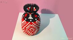 a red and black vase sitting on top of a white table next to a pink wall