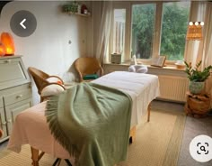 an image of a spa room setting with towels on the bed and two massage tables