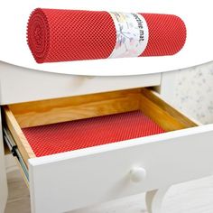 an open drawer with a red blanket on it and a white table in the background