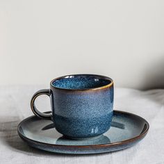 a blue cup and saucer sitting on top of a plate