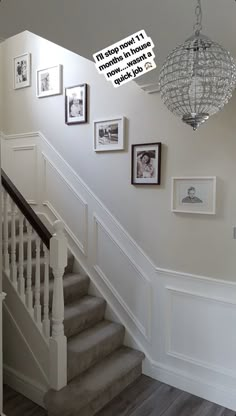 a staircase with pictures on the wall and a chandelier