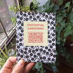 a person holding up a book in front of a potted plant with the title existent gardening written on it