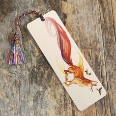 a bookmark with an image of a fox on it and a tassel attached to it