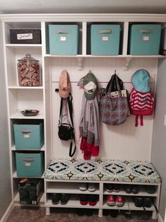 a white closet with blue bins and baskets on the wall next to it is filled with shoes