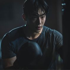 a young man wearing boxing gloves in the dark