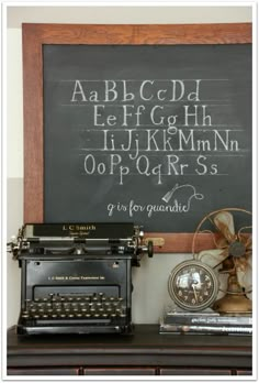 an old fashioned typewriter sitting on top of a desk next to a chalkboard