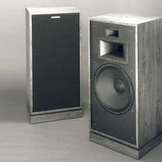 two speakers sitting next to each other in front of a gray background with no one around them