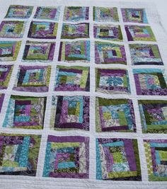 a quilted table topper with purple, green and blue squares