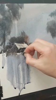 a person is drawing on a piece of paper with watercolor pencils and black ink