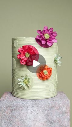 a cake decorated with flowers on top of a rock