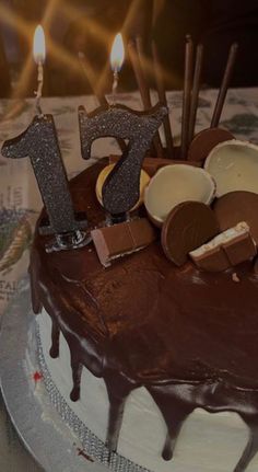 a birthday cake with chocolate frosting and lit candles on the top that says 75