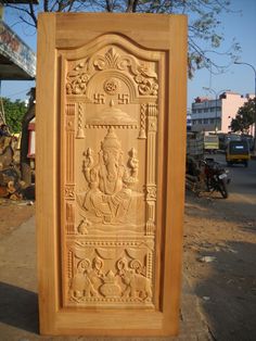 a carved wooden panel with an image of ganeshi on the front and side