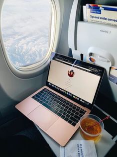 a laptop computer sitting on top of an airplane seat