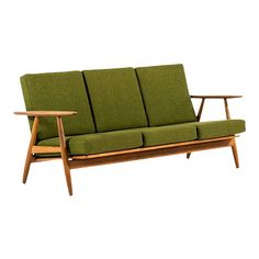 a green couch sitting on top of a wooden frame